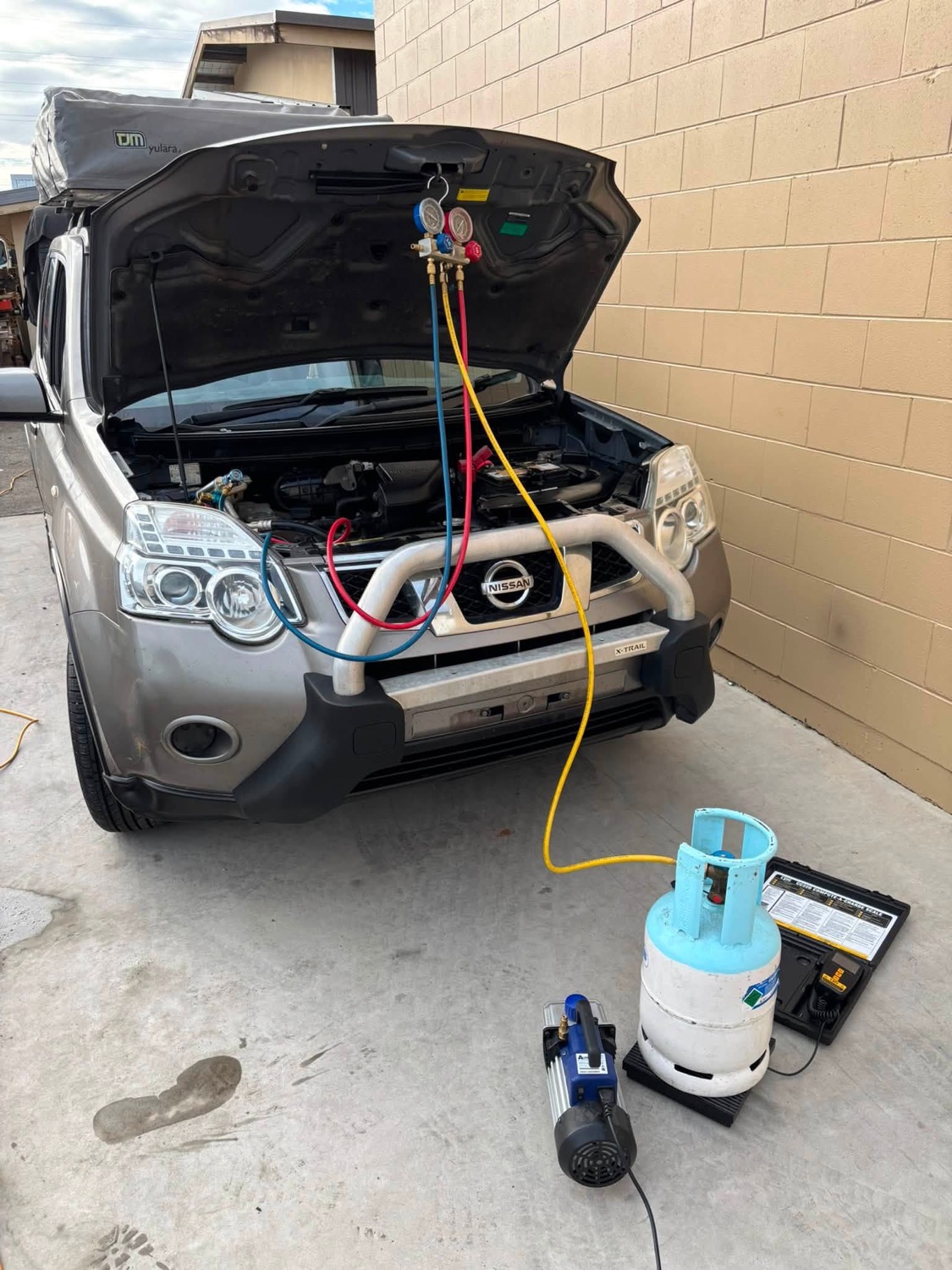 Nissan X-Trail connected to air conditioning service equipment