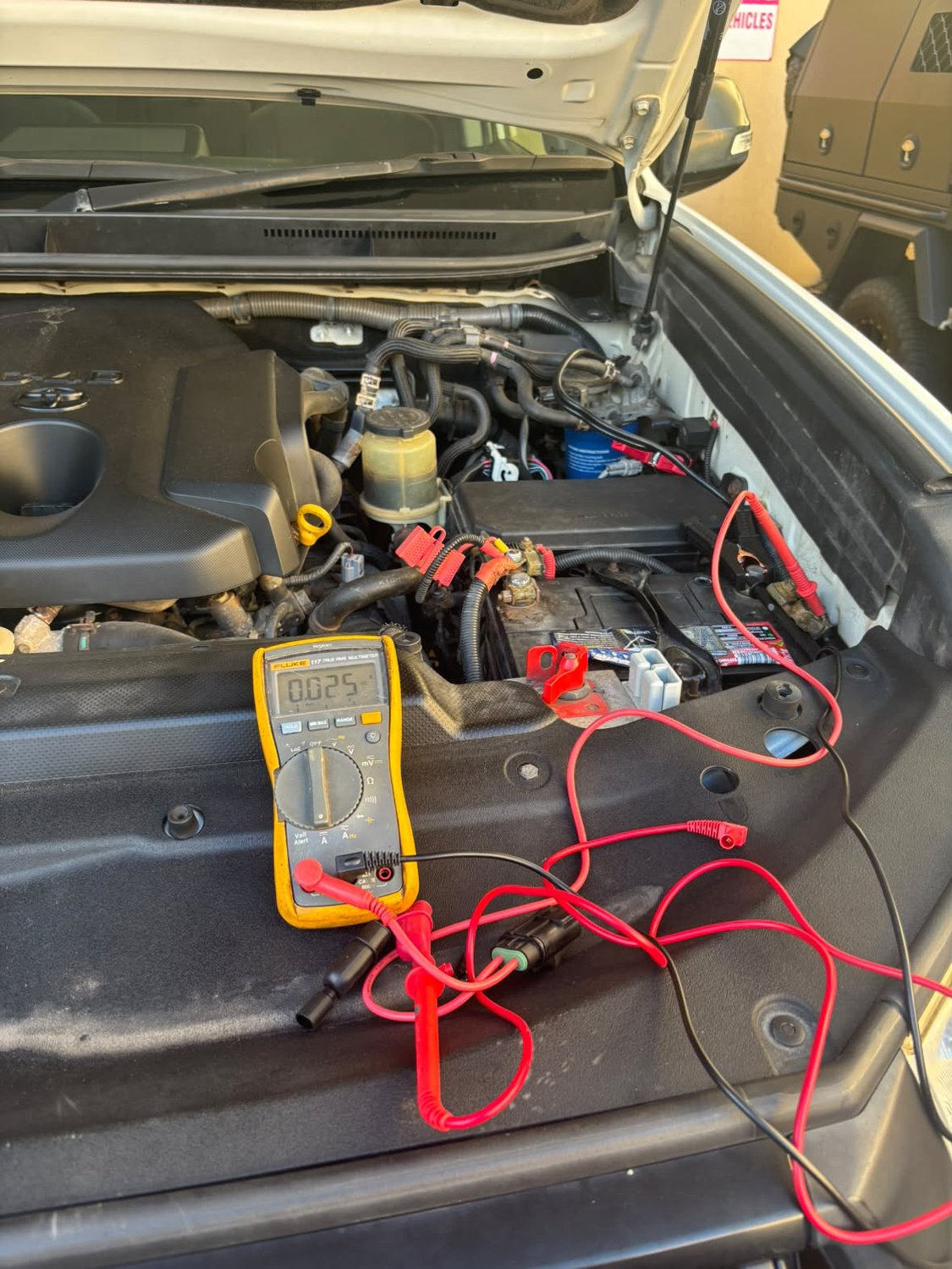 Multimeter connected at the battery during a PROVOLT fault-finding visit